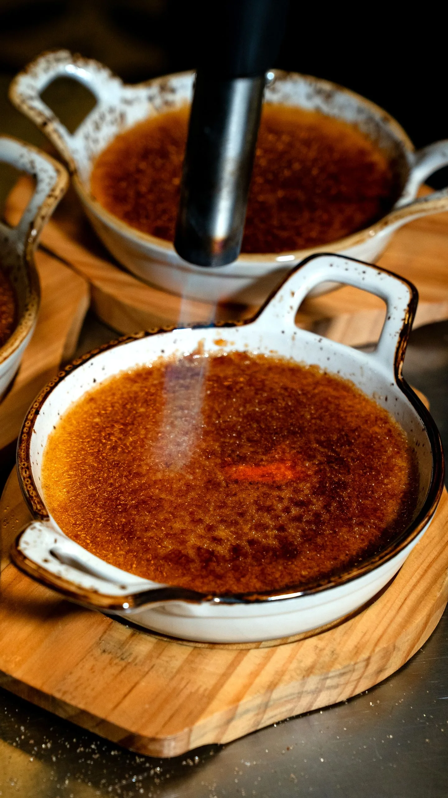 Creme brulee sugar crust being caramelized with a torch