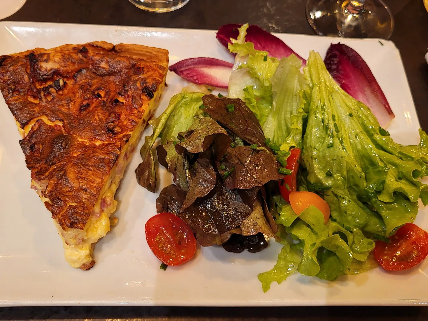 Quiche Lorraine is a savoury French pastry tart with a filling of cream, eggs and bacon or ham in an open pastry shell. It is often served with a side salad. Photographed in the restaurant La Taverne Table de Caractère in Metz