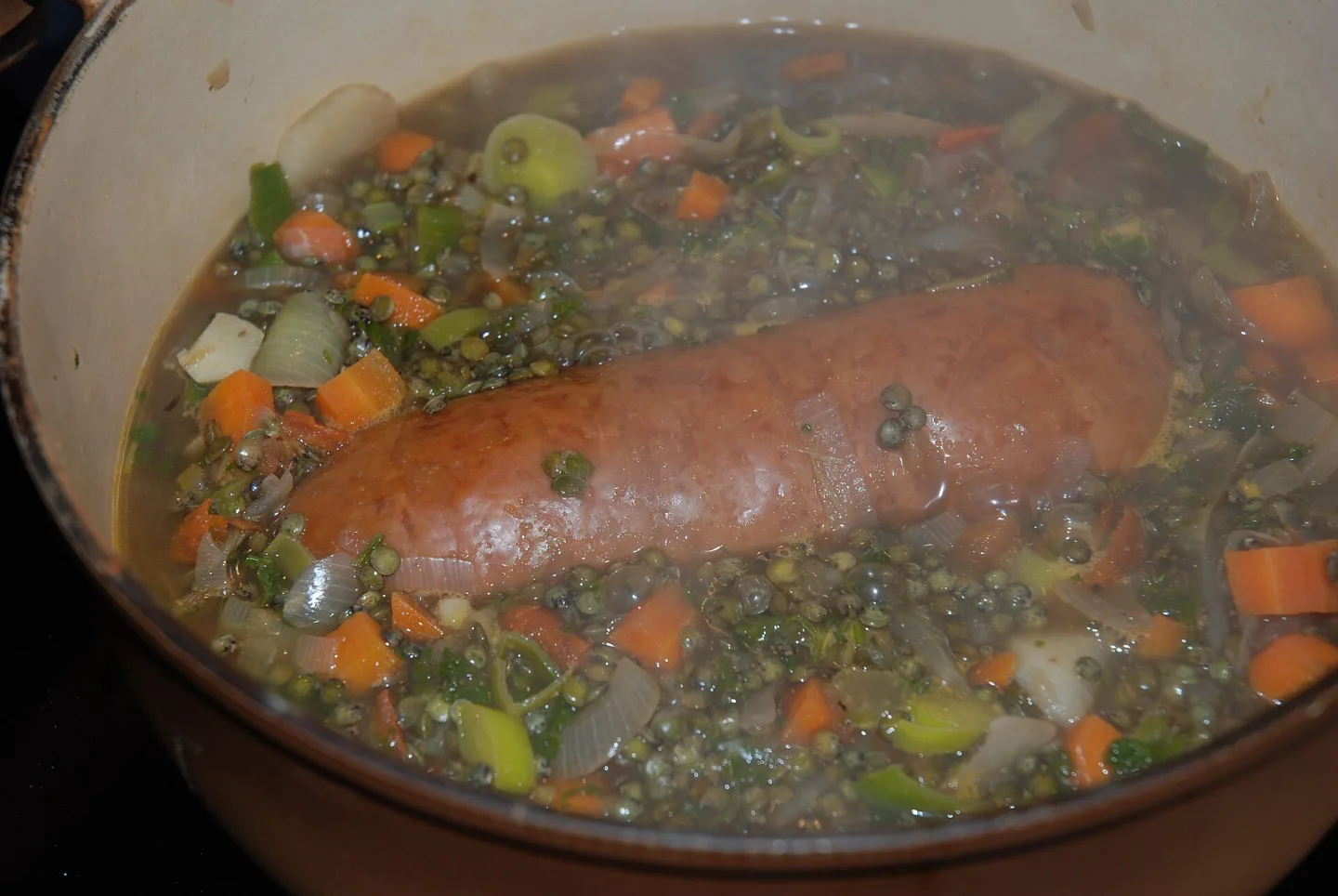 Morteau sausage simmered with lentils and diced vegetables.