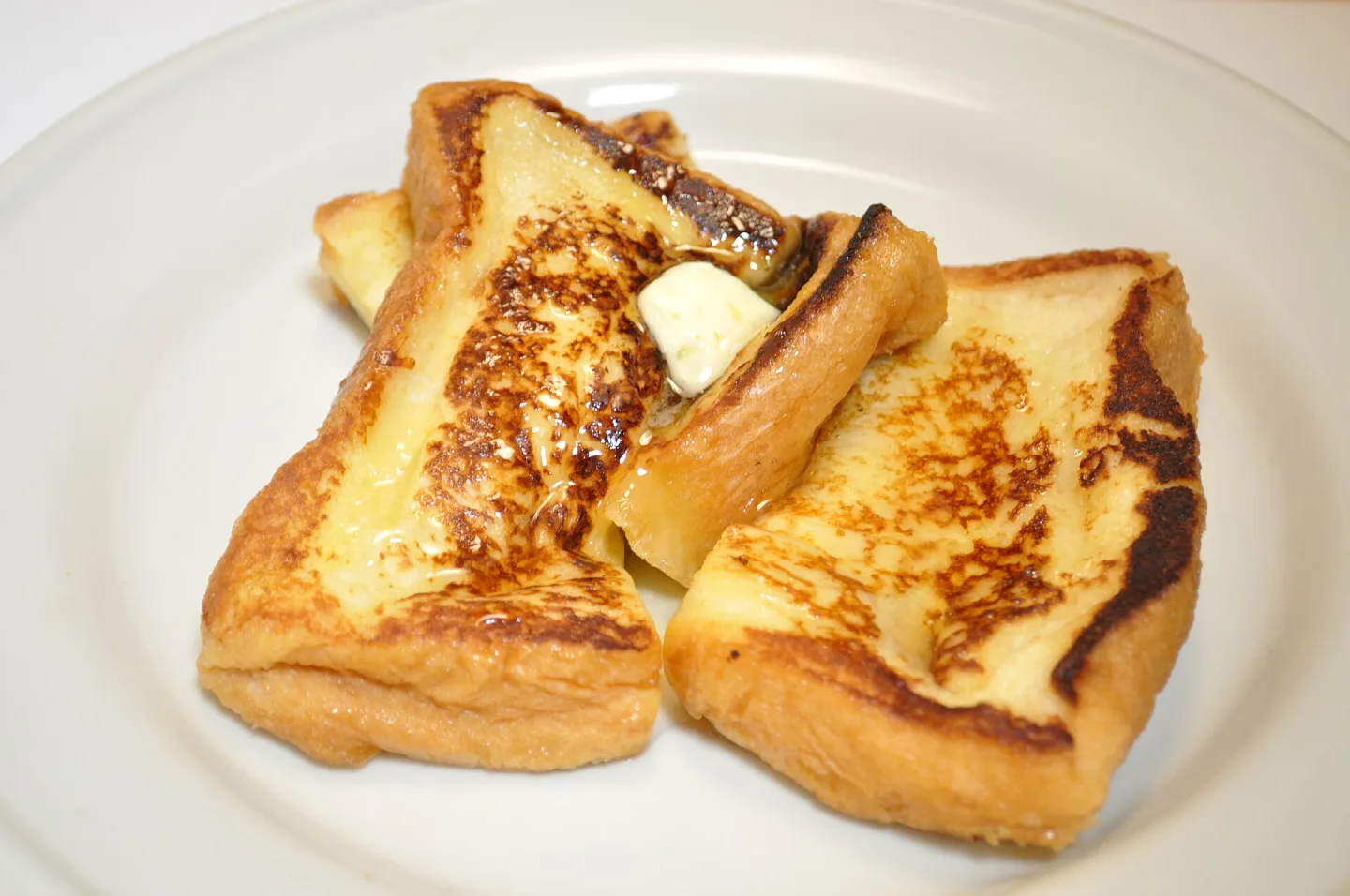 Golden slices of pain perdu served on a plate.