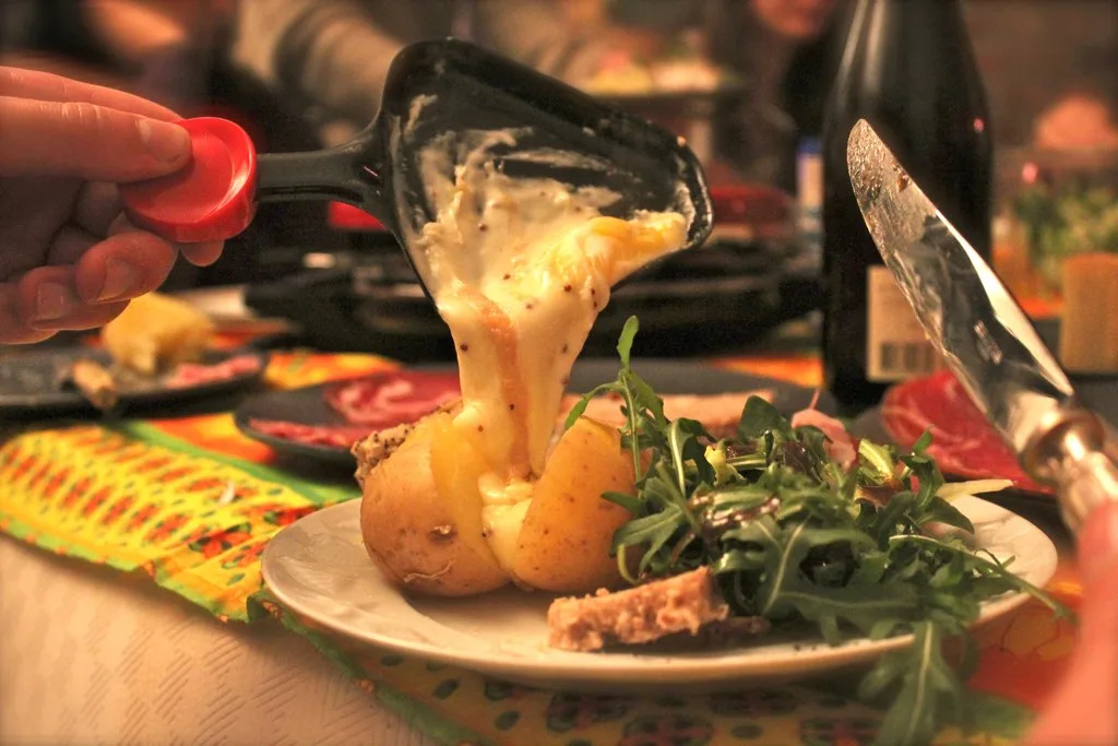 Melted raclette cheese scraped onto a plate.