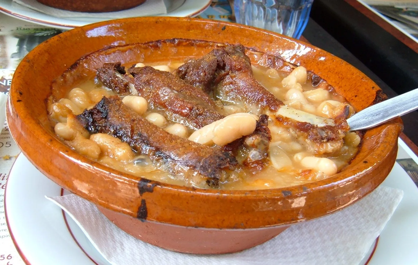 Cassoulet with white beans and meats in an earthenware dish.
