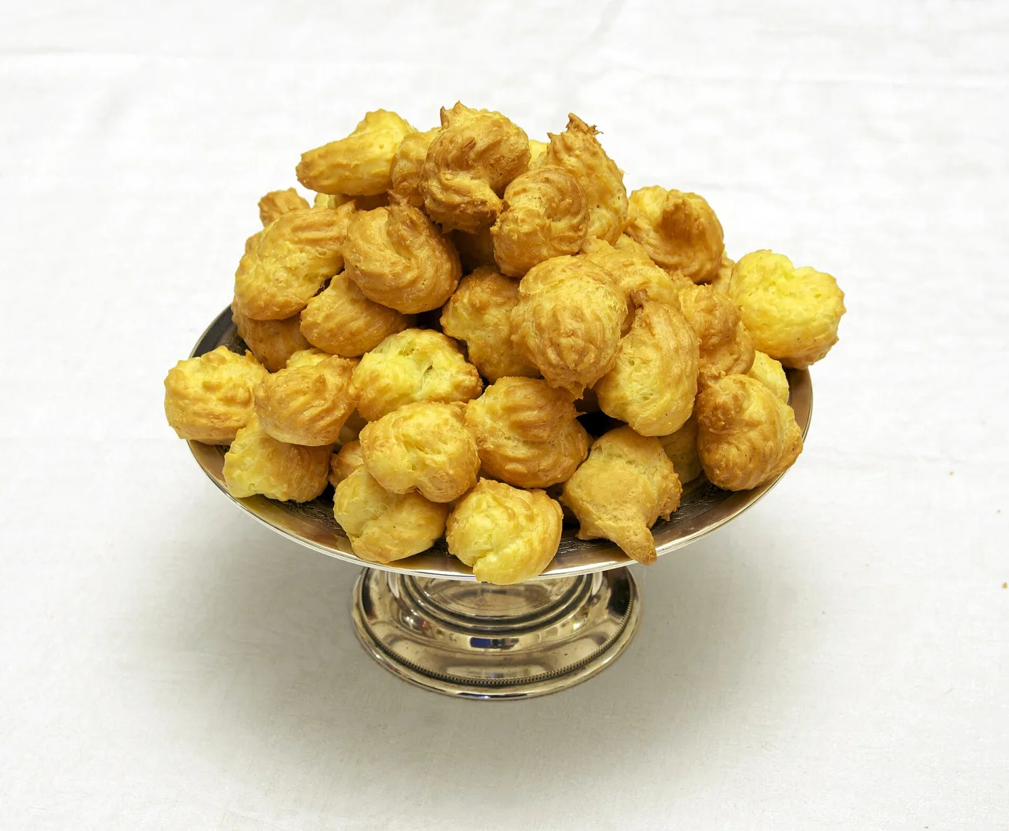 Small savory gougères piled in a serving bowl.