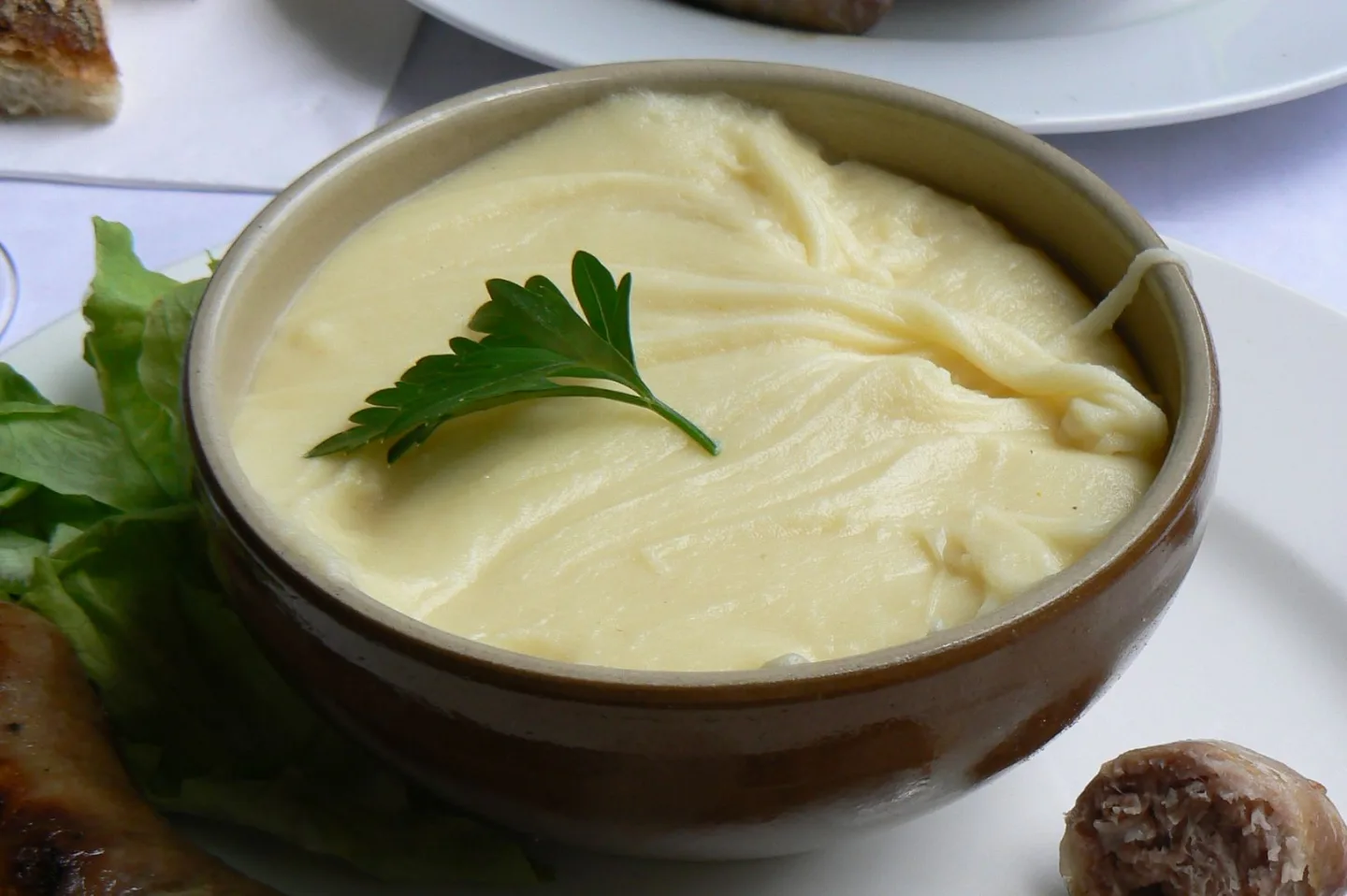 Aligot served in a bowl with sausage.