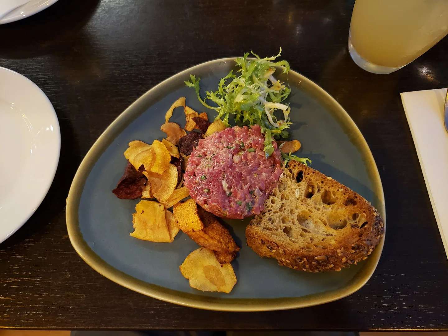 Steak tartare with bread and garnishes.